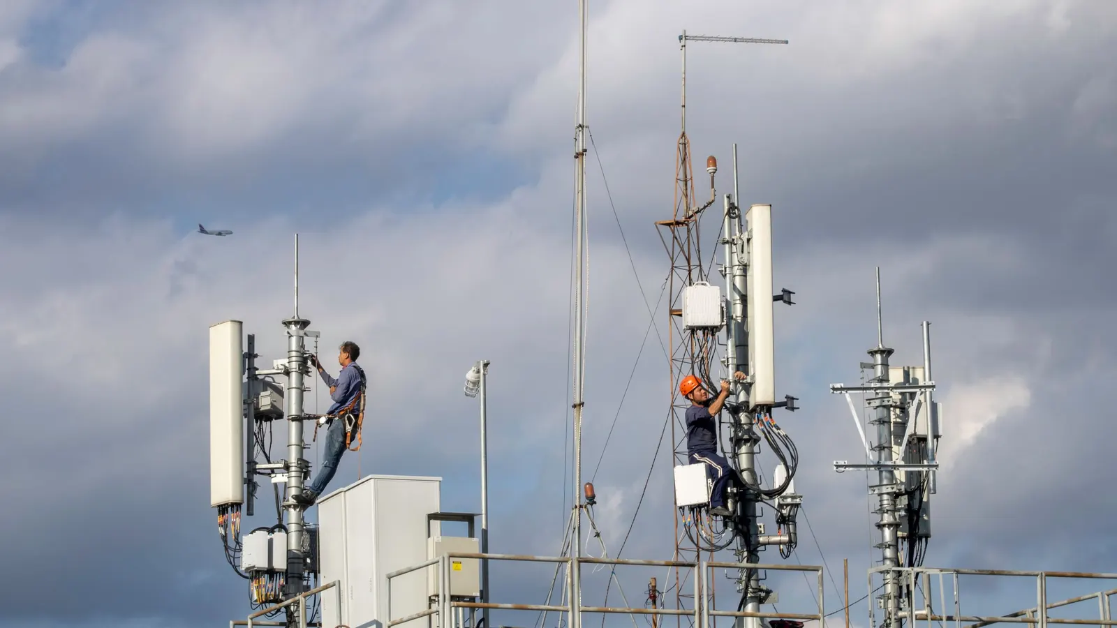 Técnico con equipo de seguridad trabajando en una torre de telecomunicaciones